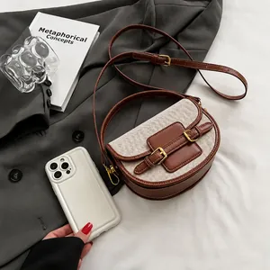 Detail of saddle bag showing brown leather and canvas texture with dual buckle design