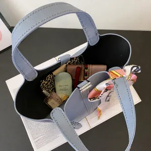 Top view of light blue leather bucket bag showing interior space with daily essentials