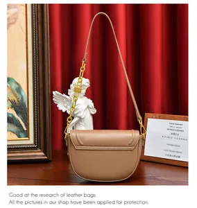 Détail du sac selle en cuir marron avec chaîne dorée et cadenas décoratif élégant