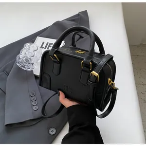 Macro detail of black Boston bag with pebbled leather texture and gold hardware accents