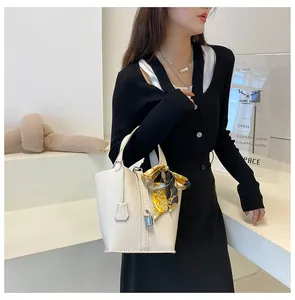 Nahaufnahme der cremefarbenen Bucket Bag aus Leder mit bedrucktem Seidentuch und Schloss
