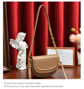 Détails du sac besace en cuir tan avec chaîne dorée et finitions de boucles élégantes
