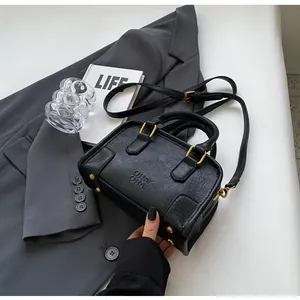 Close-up of black lychee texture Boston bag featuring gold hardware and ORNI ORNI logo