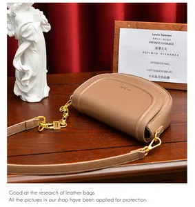 Gros plan détaillé d'un sac besace caramel avec chaîne dorée et logo gravé