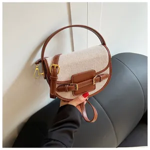 Detail of vintage saddle bag featuring brown leather trim and canvas texture
