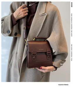 Close-up of dark brown vintage satchel with gold lettering and adjustable leather strap