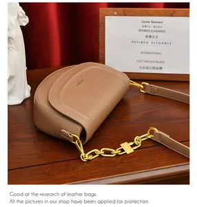 Détail du sac selle marron clair montrant les coutures et la chaîne dorée sur cuir