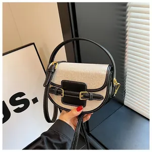 Detail of canvas saddle bag with black leather trim and white contrast stitching