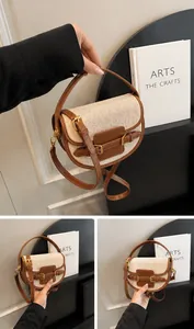 Detailed close-up of brown leather and canvas saddle bag with golden metal hardware