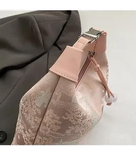 Detailed view of pink velvet handbag with traditional embroidery and stitching