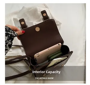 Detailed view of the dark brown satchel interior capacity with tablet and phones