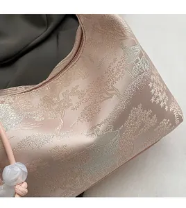 Close-up of pink satin bag with traditional Chinese embroidery and beaded handle