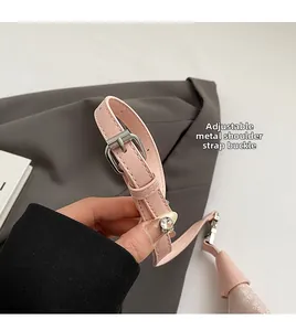 Close-up of pink leather strap with adjustable silver metal buckle and neat stitching