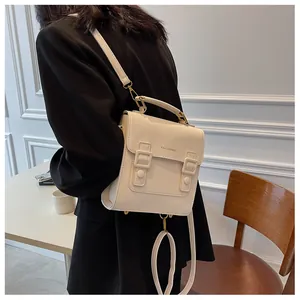 Detail showing cream-colored leather texture and golden metal buckle on vintage backpack