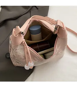 Internal view showing the spacious capacity of this pink jacquard cloud bag with cosmetics
