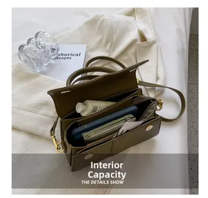 Structure interne à trois compartiments du sac à bandoulière olive montrant la capacité