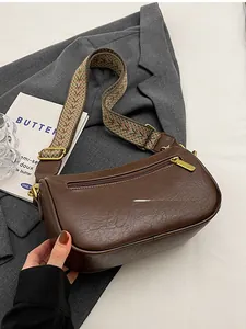 Detail view of vintage dark brown crossbody bag featuring a back zipper pocket and wide strap