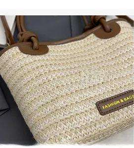 Vue détaillée du sac seau en paille tissée avec garniture en cuir brun et étiquette mode