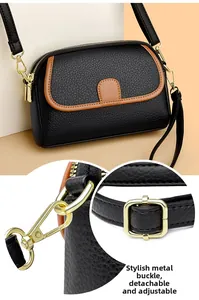 Close-up of golden metal hardware and adjustable leather strap on black crossbody bag