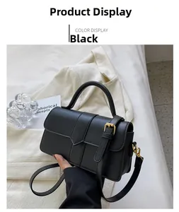 Détail du sac à bandoulière noir avec cuir texturé, rabat en V et boucle dorée élégante