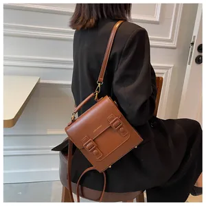 Detailed view of brown vintage messenger bag with top handle and kaxiu bags logo