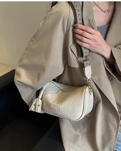 Detail of beige textured shoulder bag with bohemian jacquard strap and tassels