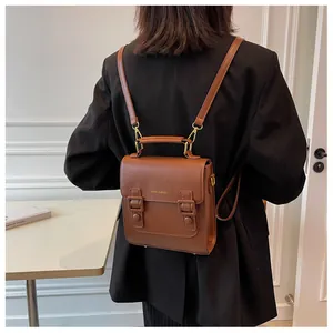 Detail of caramel vintage leather backpack with gold brand logo and adjustable straps