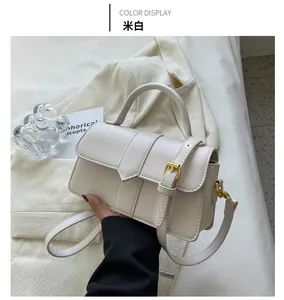 Détail du sac bandoulière blanc crème en cuir avec boucle et ferrures dorées