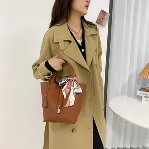 Klassische karamellbraune Lederbeuteltasche für Damen mit floralem Tuch und Schloss