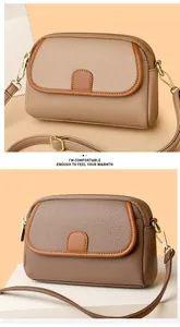 Macro shot of litchi pattern leather texture and dual gold zipper detail on brown crossbody bag
