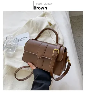 Vue détaillée du sac bandoulière en cuir synthétique marron avec boucles dorées
