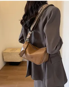 Detail of vintage brown pebble leather hobo bag with colorful woven ethnic shoulder strap