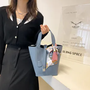 Hellblaue Eimer-Handtasche aus Leder mit Seidenschal und Metalldetails am Griff