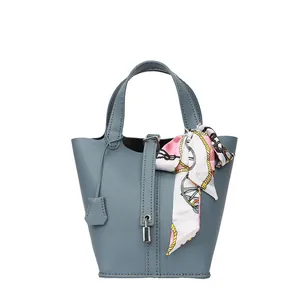 Blaue Leder-Eimertasche mit Lychee-Muster und dekorativem floralem Seidentuchgriff