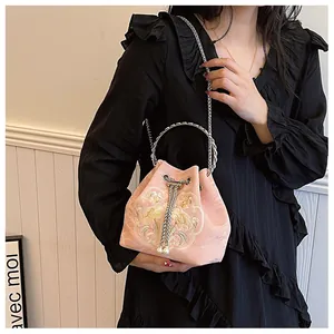 Dettaglio ricamo su borsa a secchiello in raso rosa con coulisse di perle e manico