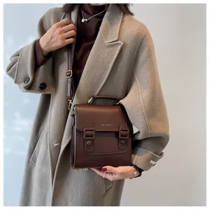 Close-up of vintage brown leather satchel with dual straps and top handle for women