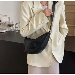 Chique zwarte halve maan crossbody tas gecombineerd met beige blazer voor kantoorstijl