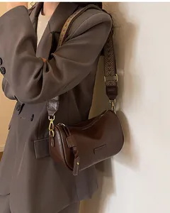 Detail of vintage dark brown semi-circle bag with patterned wide strap and smooth finish