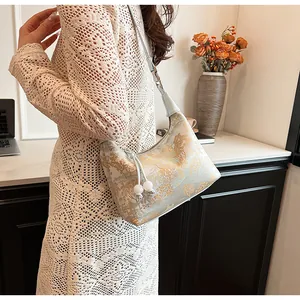 Detail of light blue beaded handbag with gold floral embroidery and drawstring design
