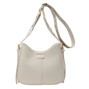 Off-white faux leather bucket bag with vintage patterned wide strap and gold hardware