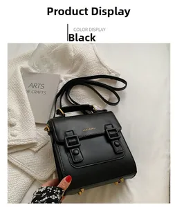 Detail of black leather handbag with gold buckles on a stylish lifestyle background
