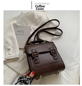 Detail of coffee brown vintage satchel showing leather texture and double buckle straps