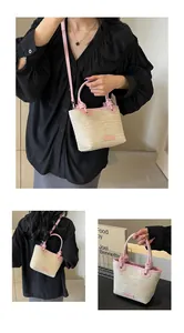 Sac seau en paille avec garniture en cuir rose et poignées sous plusieurs angles