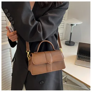 Sac bandoulière en similicuir marron avec détails dorés et bandoulière réglable en situation