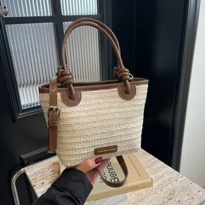 Sac seau bicolore en paille avec anses en cuir marron et bandoulière réglable