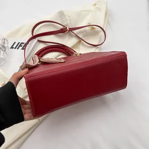 Red crocodile embossed handbag with silk scarf detail and woven top handle