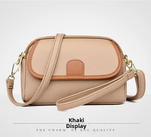Detail of khaki leather crossbody bag with lychee texture and adjustable shoulder strap