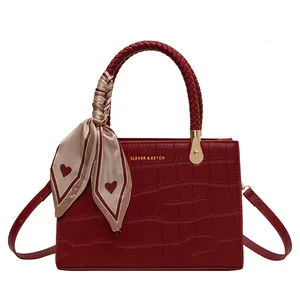 Elegant wine red crocodile embossed handbag with woven handle and silk scarf detail