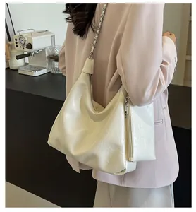 Detail of soft pleated cream tote bag with silver chain strap and small coin purse attachment