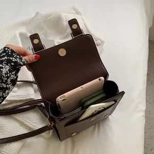 Vintage brown leather crossbody bag with open flap showing spacious interior storage